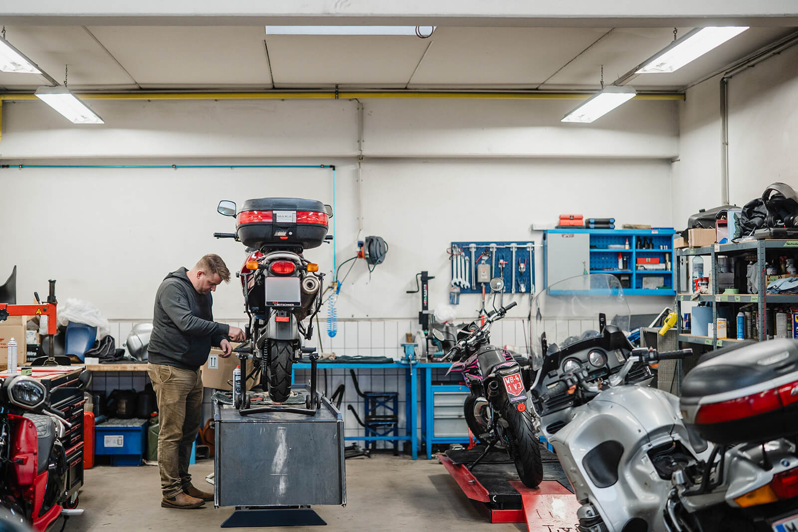 Mechaniker überprüft die Kette eines Motorrads beim Saisoncheck in der Werkstatt