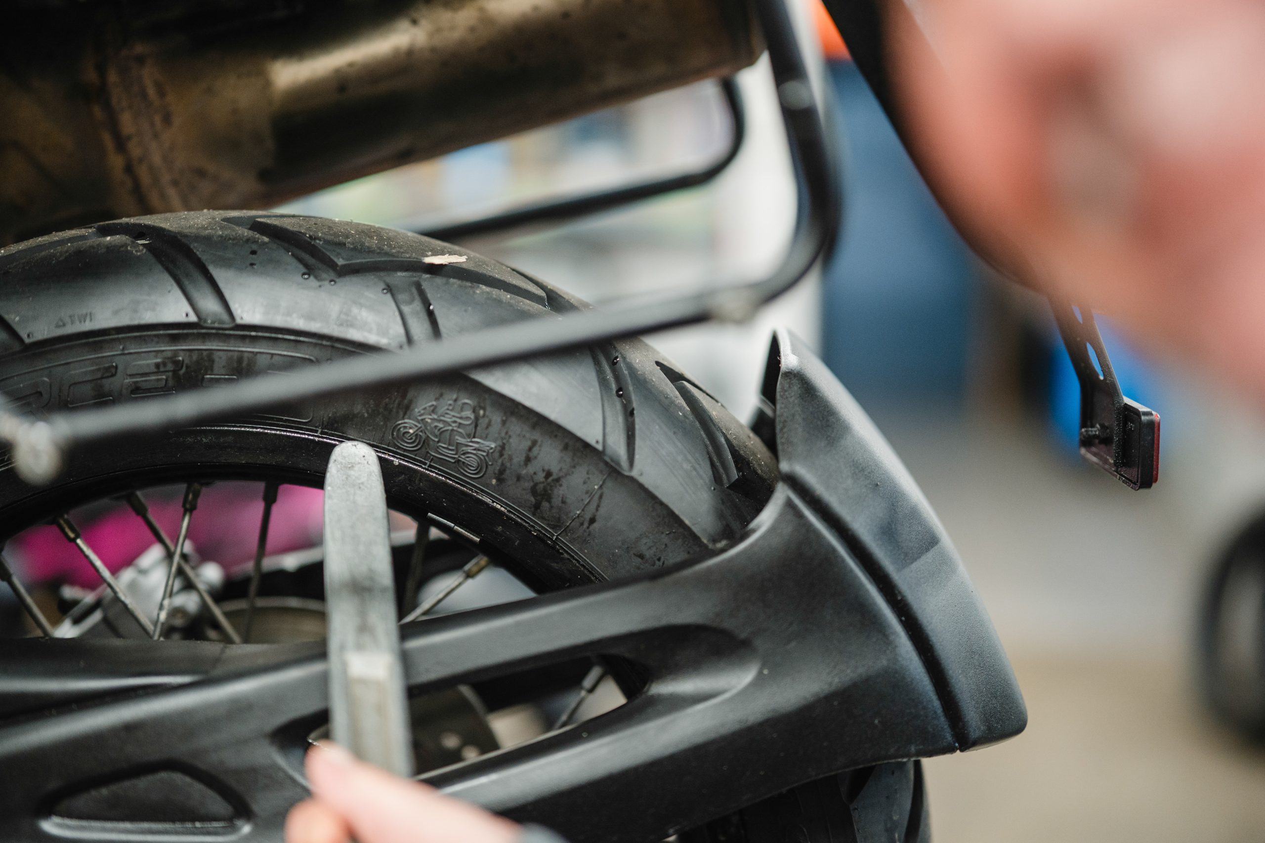 Nahaufnahme eines Motorradreifens bei der Kontrolle von Profil und Zustand in der Werkstatt
