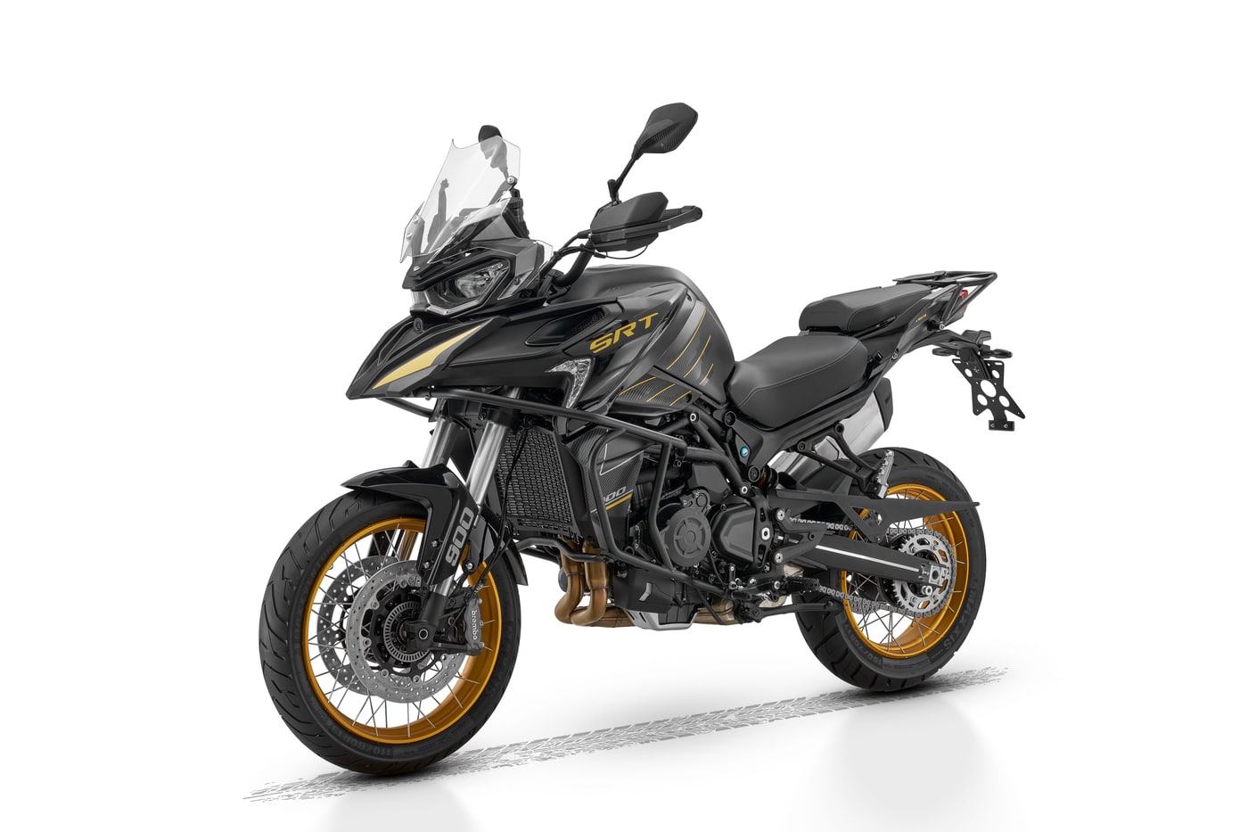 Schwarzes QJMOTOR Adventure-Motorrad mit goldenen Felgen in schräger Frontansicht vor weißem Hintergrund
